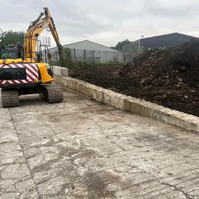 a bulldozer digging a pile of dirt in a parking lot