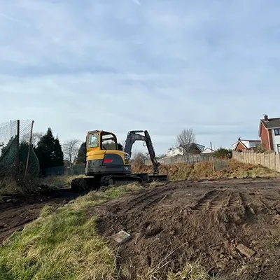 a bulldozer is parked on the side of a dirt road