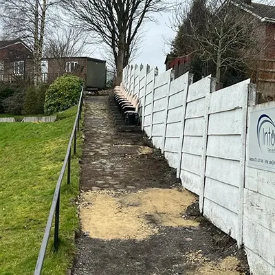 a row of white picket fence next to a green field
