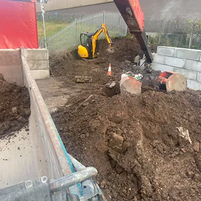 A pile of dirt with a bulldozer in the background.