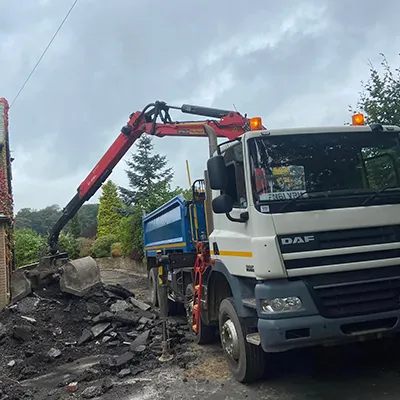 A dump truck is parked next to a building.