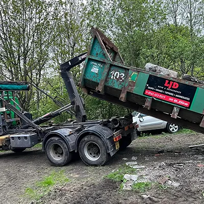 A dump truck with a dumpster attached to the back of it.