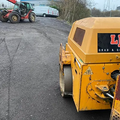 a large yellow machine sitting on the side of a road